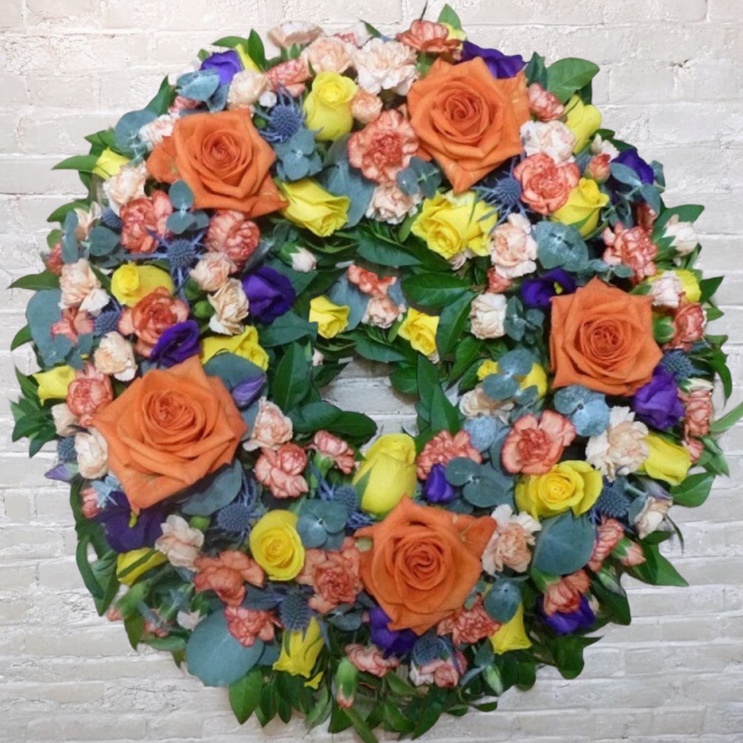 Aranjament funerar pe rotund dintr-un mix de flori