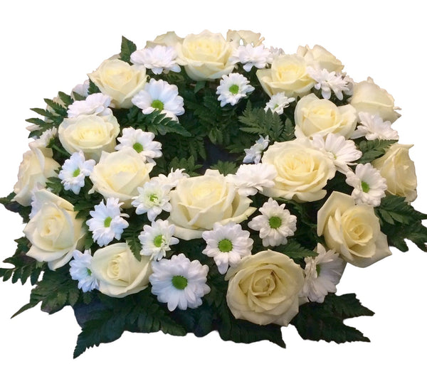 Round funeral wreath with roses and daisies