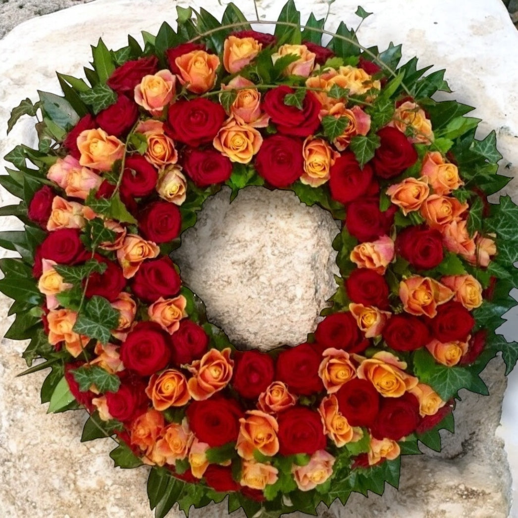 Coroana funerara rotunda din trandafiri rosii si portocalii