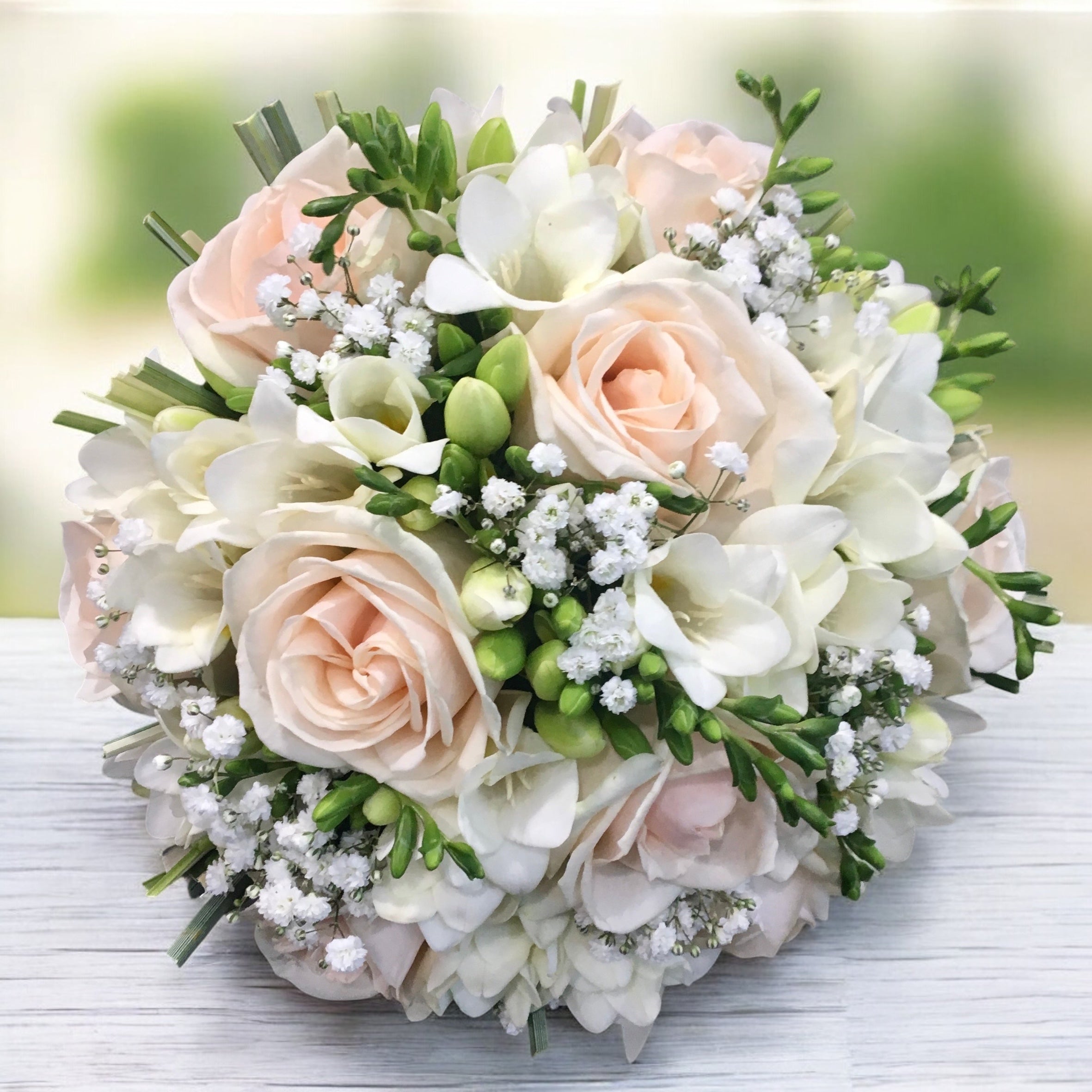 Bridal bouquet with purple roses and white freesias