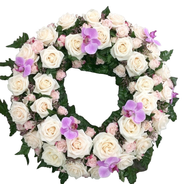 The round funeral wreath of roses and mini-roses