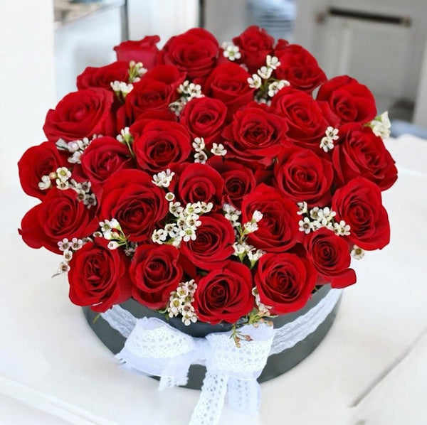 Floral arrangements in a round box red roses