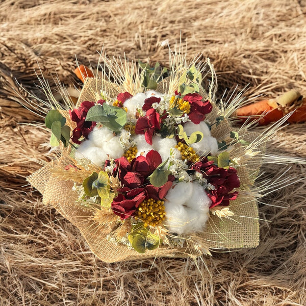 Rustic wedding bouquet of ears of wheat, cotton and craspedia