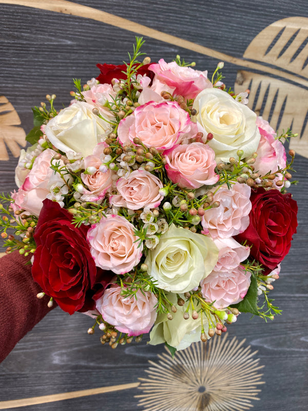 Wedding bouquet of cream roses and red mini roses