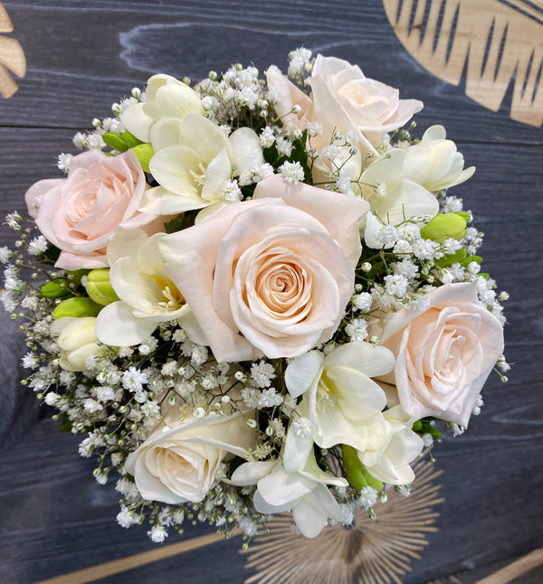 Wedding bouquet of cream roses and white freesias