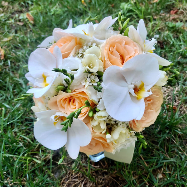 Wedding bouquet of peach roses and orchids