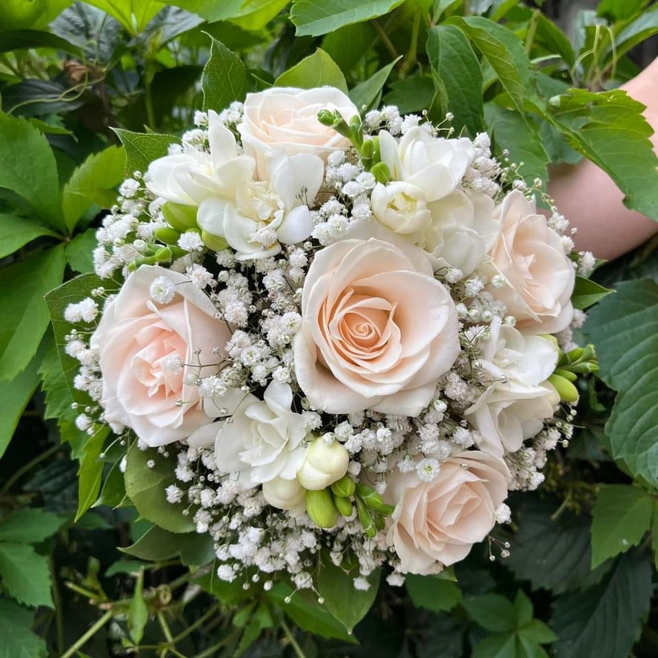 Wedding bouquet of cream roses and white freesias