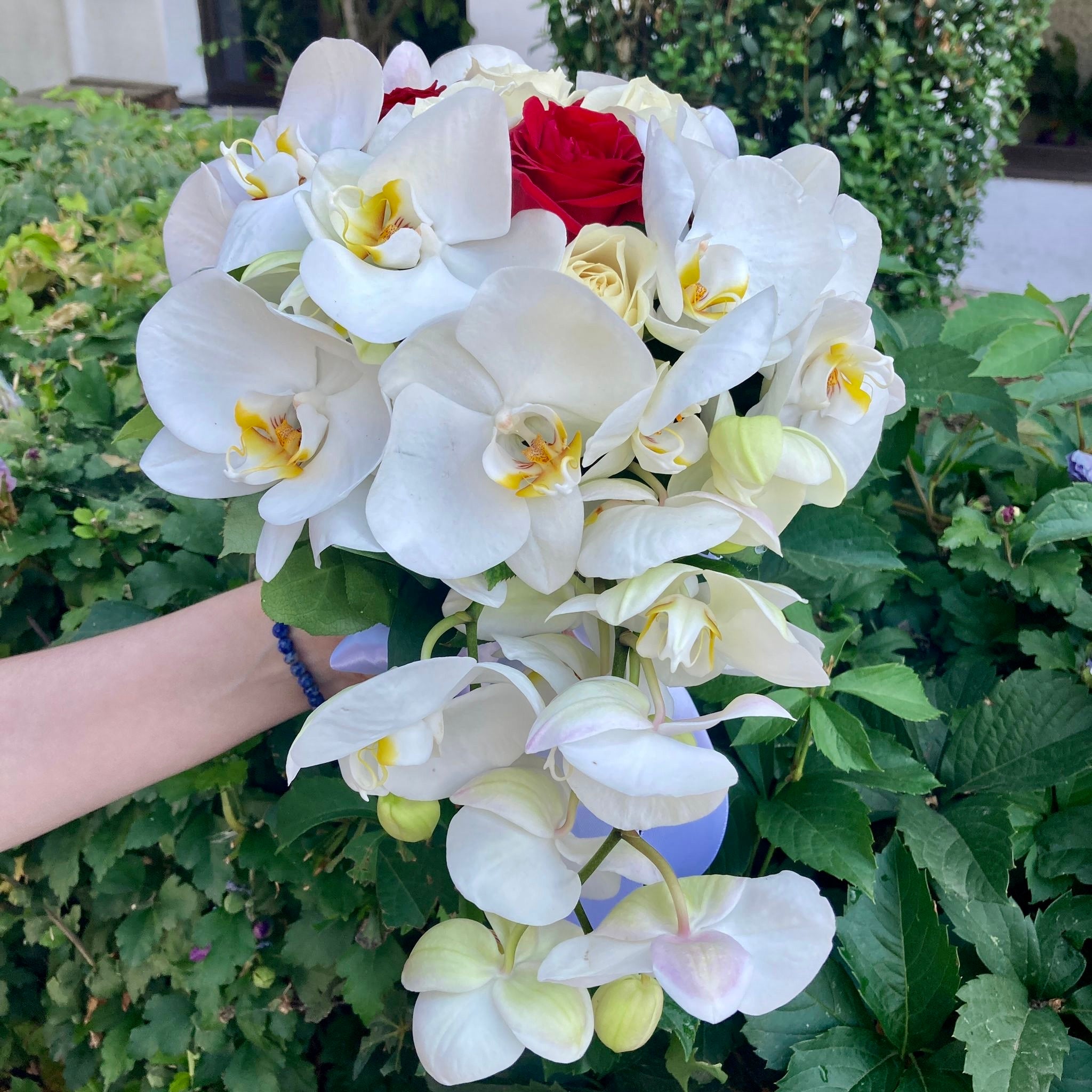 Flowing bridal bouquet with roses and phalaenopsis orchids