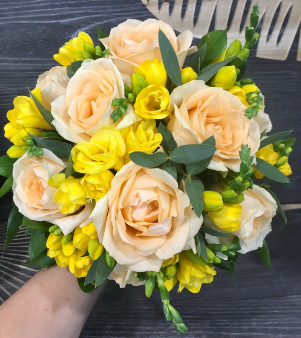 Bridal bouquet with peach roses and white freesias