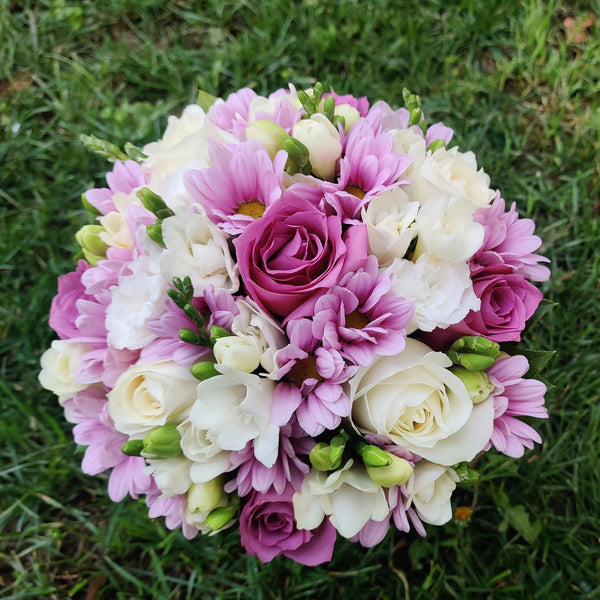 Bridal bouquet with purple roses, freesias and daisies