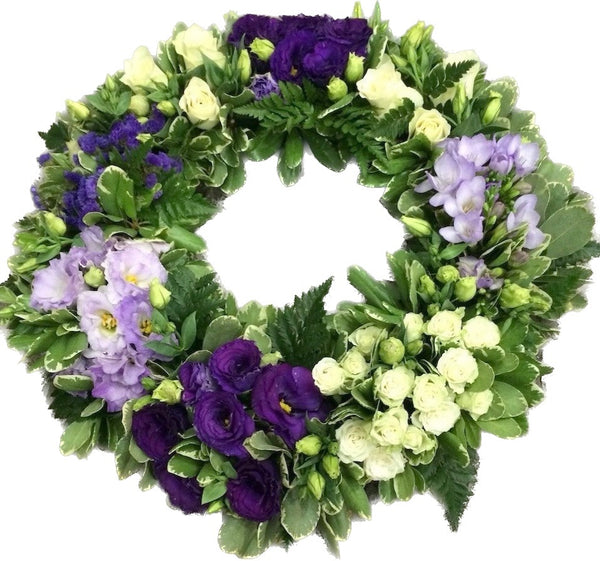 Round funeral wreath roses, lisianthus and freesias
