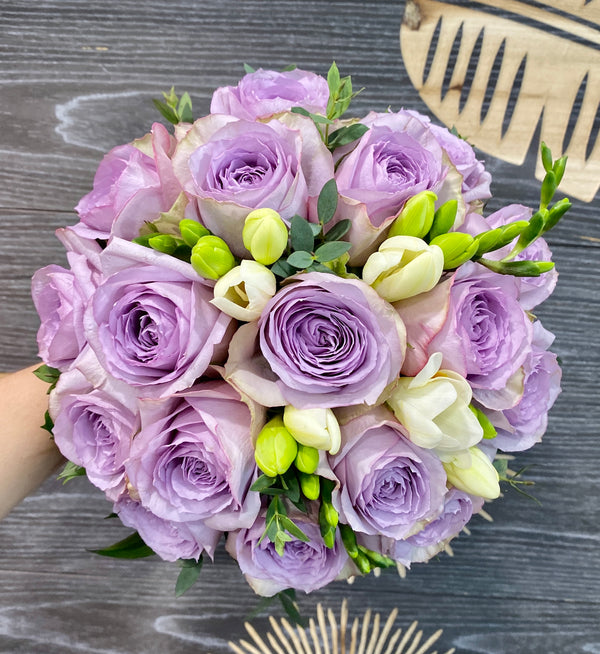 Bridal bouquet of purple roses and freesias