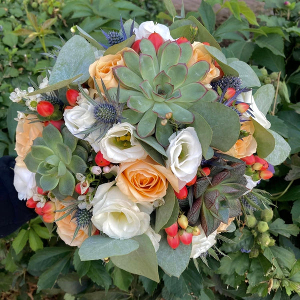 Bridal bouquet of roses, hypericum and succulent plants