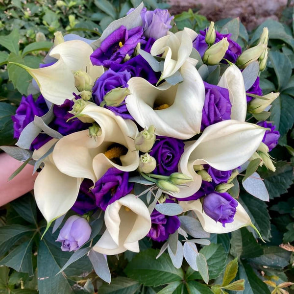 Bridal bouquet of white callas and purple lisianthus