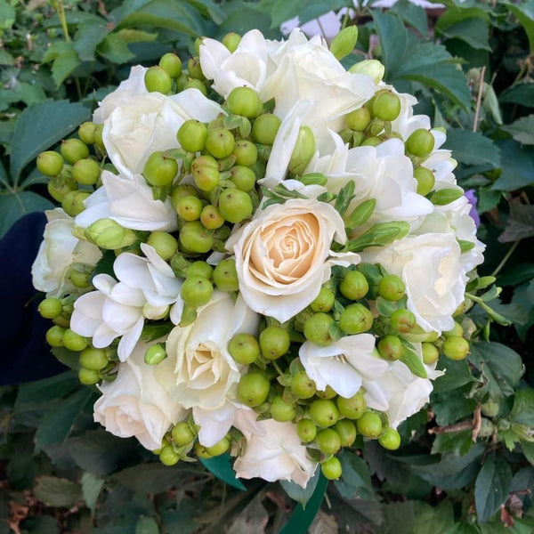Bridal bouquet with roses, freesias and green hypericum