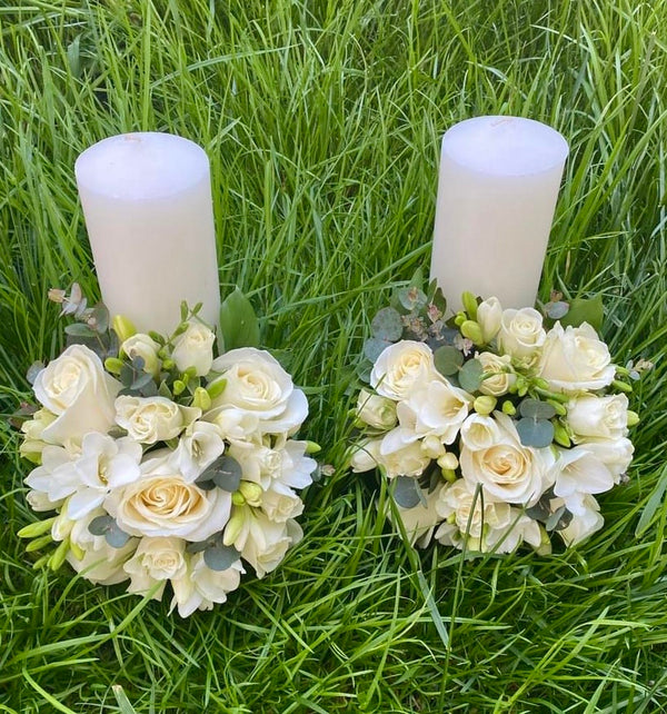 Short white roses and lisianthus wedding candles