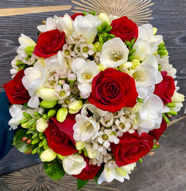 Bridal bouquet of red roses and white freesias