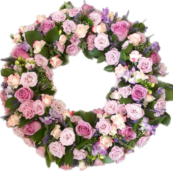 Round funeral wreath of roses and freesias