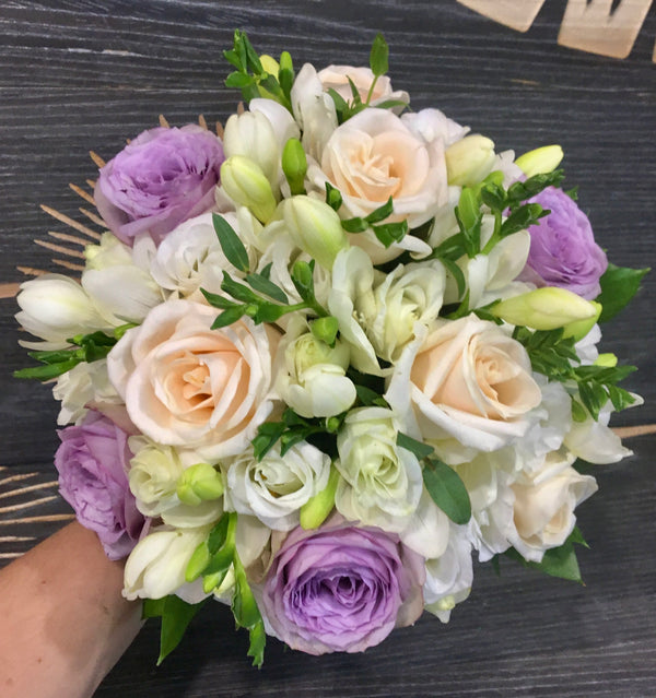 Bridal bouquet of purple roses, freesias and mini roses