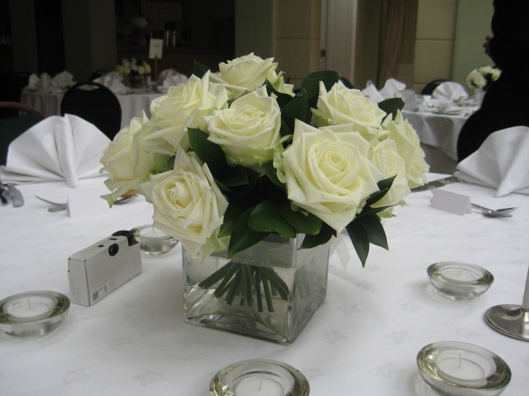 Aranjament floral din trandafiri albi si ruscus