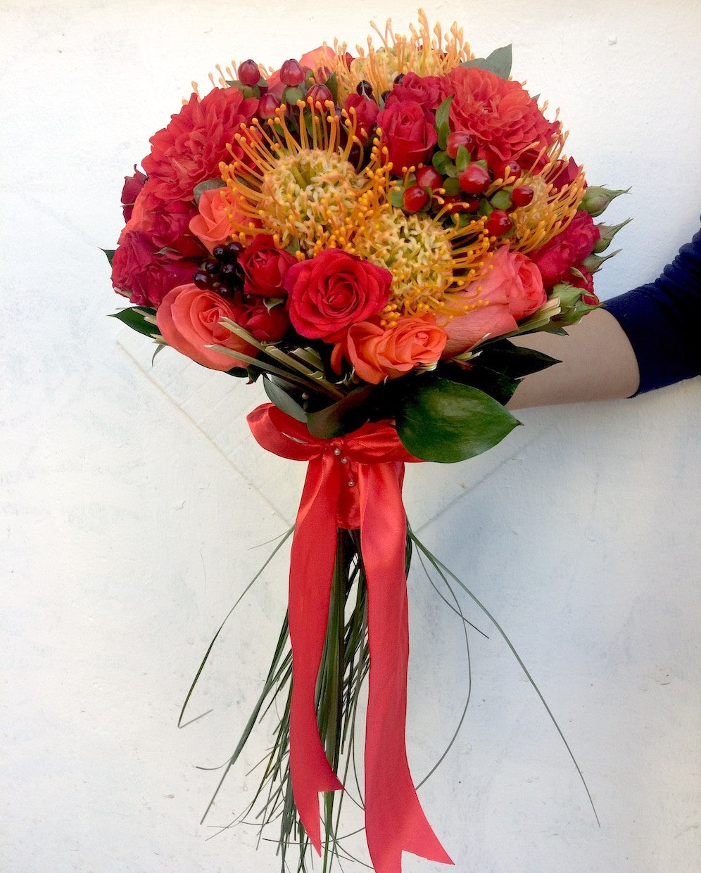 Buchet de mireasa glob din leucospermum, trandafiri, hypericum, minirose