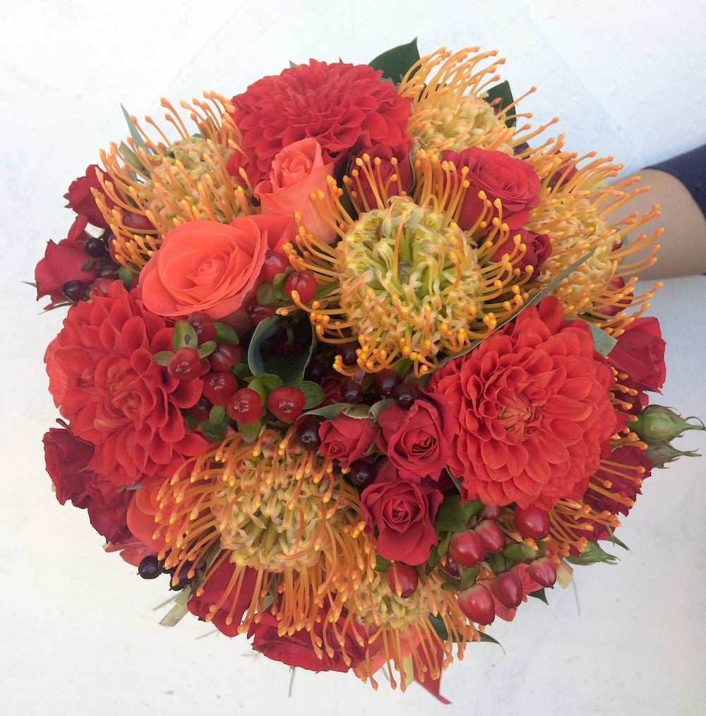 Buchet de mireasa glob din leucospermum, trandafiri, hypericum, minirose