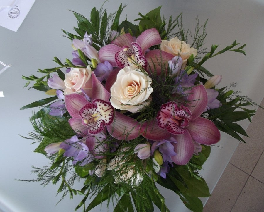 Aranjament floral cu frezii mov, orhidee roz si trandafiri crem