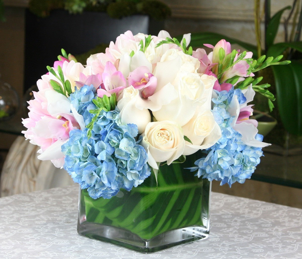 Aranjament de masa din hortensii, trandafiri, frezii si orhidee cymbidium