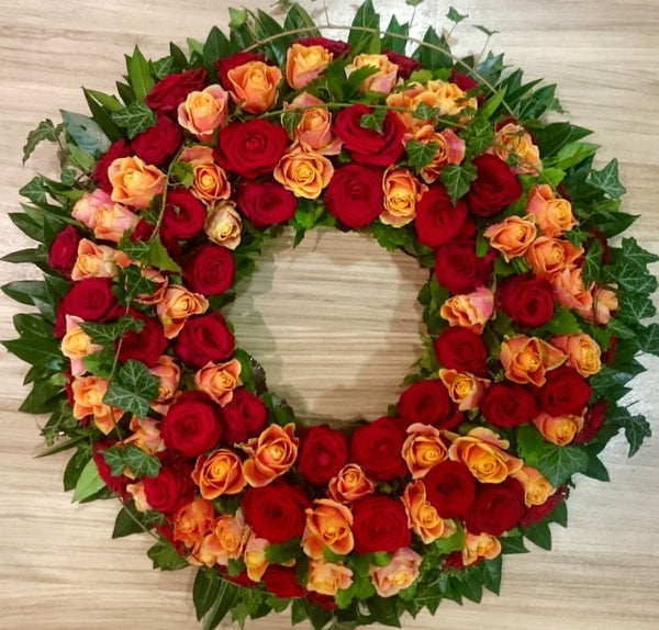 Coroana funerara rotunda din trandafiri rosii si portocalii