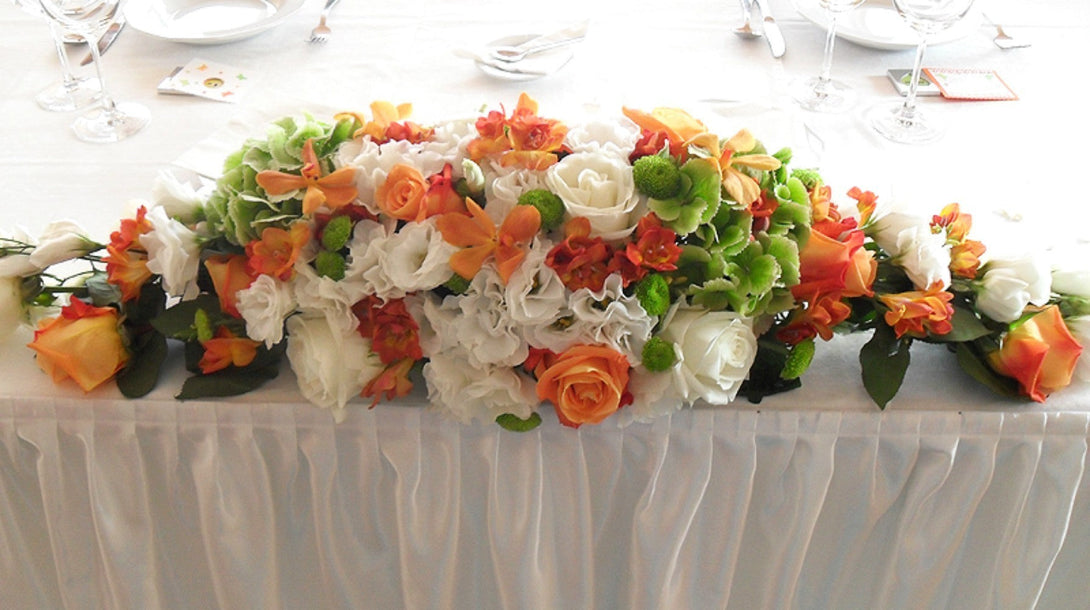 Aranjament de prezidiu portocaliu cu trandafiri, lisianthus, hortensie si orhidee mokara