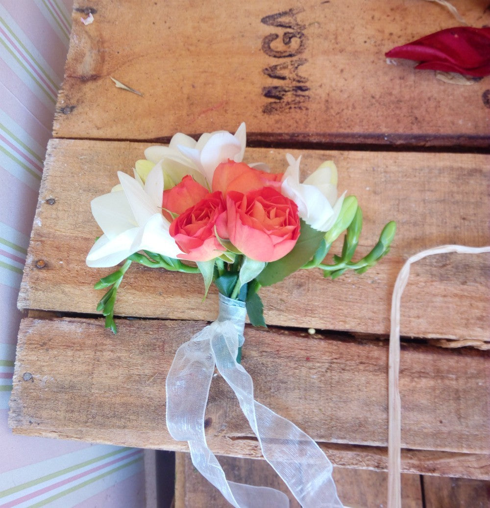 Corsaj din frezii albe si minirose portocalii