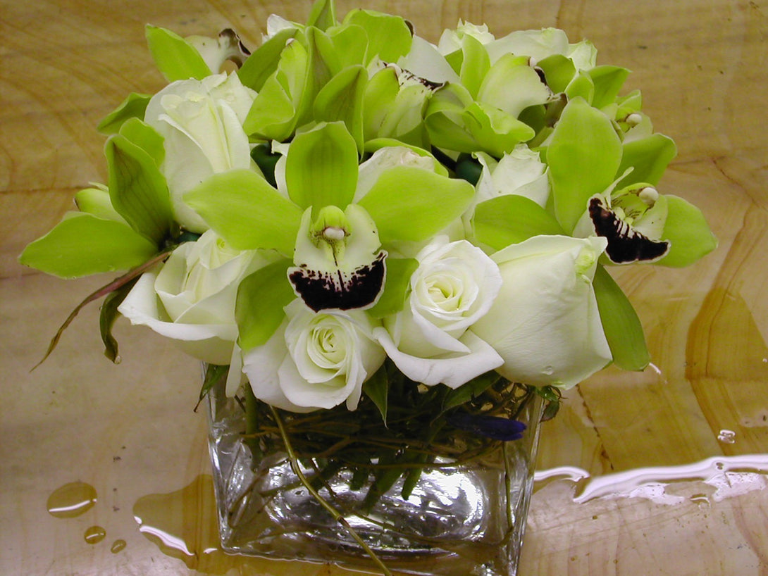 Aranjament floral din orhidee imperiala si trandafiri albi in vas de sticla