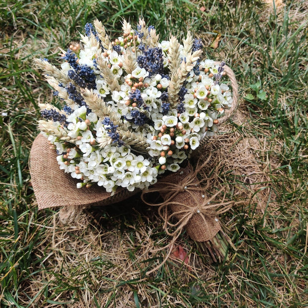 Rustic wedding bouquet with ears of wheat and wax flowers