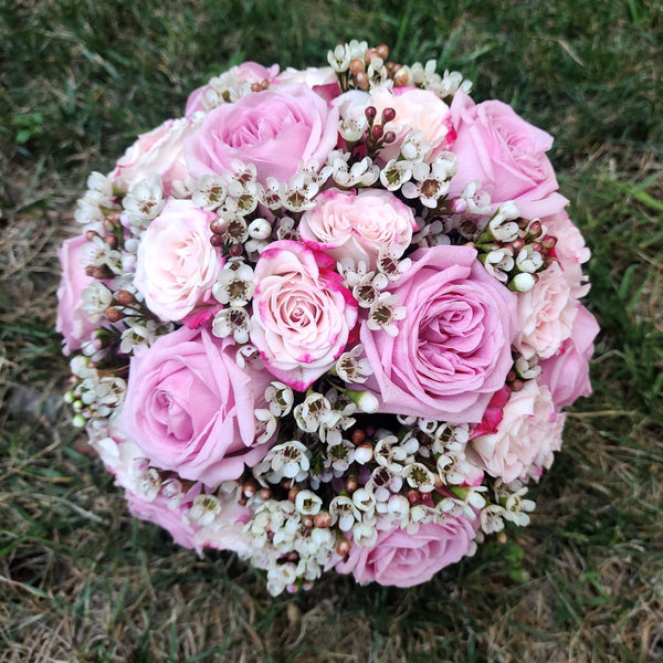 Wedding bouquet of pink roses and wax flowers