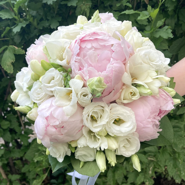 Wedding bouquet with pink peonies, freesias and lisianthus