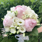 Wedding bouquet with pink peonies, freesias and lisianthus