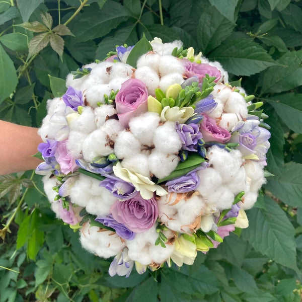 Wedding bouquet with lilac roses and cotton flowers