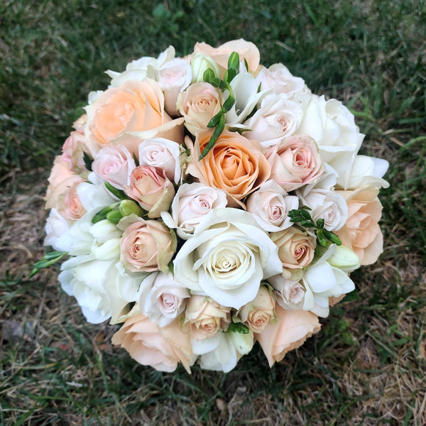 Bridal bouquet of peach roses and mini cream roses